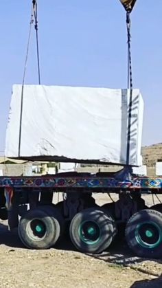 a semi truck with large tires attached to it's flatbed in the desert