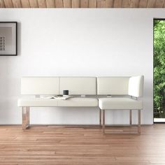 a white couch sitting on top of a hard wood floor next to a wooden wall