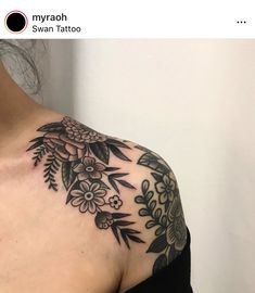 a woman's shoulder with flowers and leaves on it