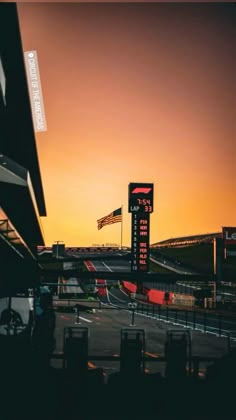 the sun is setting over an empty race track