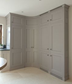 an empty room with cabinets and a table in the corner, next to a window