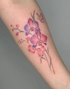 a woman's arm with pink and purple orchids on the left inner forearm