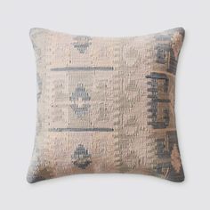 a beige and blue pillow with an intricate design