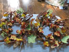 two wreaths made out of fake flowers on a table