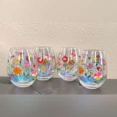 four wine glasses with flowers painted on them