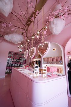 the interior of a store with pink walls and ceiling decorated with hanging heart - shaped decorations