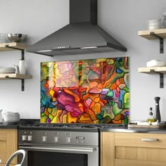 a kitchen with an oven, stove and wall hanging art piece on the back splash