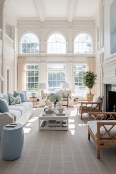 a living room filled with lots of furniture and large windows in the wall above them