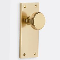 an image of a door handle on a white wall with gold knobs and handles