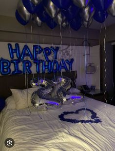 a bed with blue balloons and the words happy birthday on it