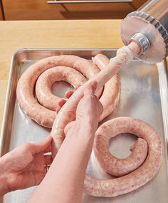 a person is washing two sausages in a pan