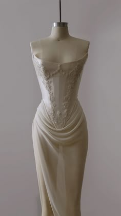 a white dress on a mannequin in front of a gray background