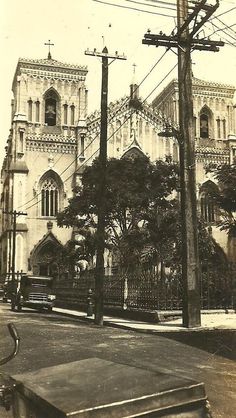 an old black and white photo of a church in the middle of town with power lines above it