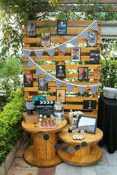 a wooden table topped with pictures next to a black and white flag on top of a fence