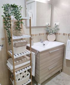 a bathroom with a sink, towel rack and plants in the corner on the shelf