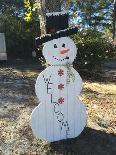 a snowman made out of pallet wood with the word welcome on it's face