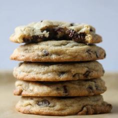 a stack of chocolate chip cookies sitting on top of a wooden table