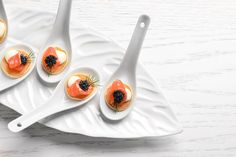 small appetizers with salmon and blackberries on white serving tray