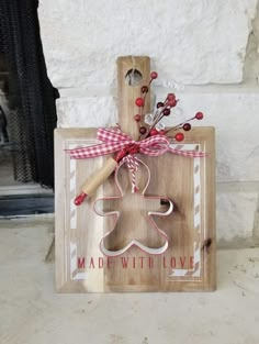 a wooden cutting board with a gingerbread cookie on it and a red ribbon tied around the handle