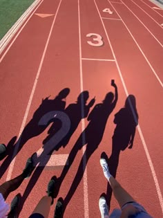 several people standing on a track with numbers painted on it