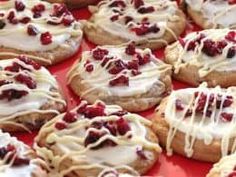 there are many cookies with icing and cranberry toppings on top of them