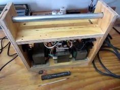 the inside of a wooden box with wires and other electrical equipment on top of it