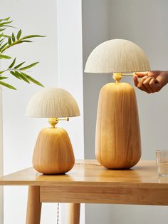 two wooden lamps sitting on top of a table