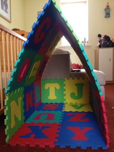 a child's play tent with letters and numbers on it in the middle of a room