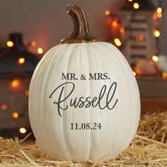 a white pumpkin with the words mr and mrs russell engraved on it sitting in hay