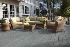 a wooden deck with wicker furniture on it