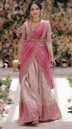 a woman in a pink sari walks down the runway