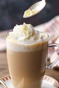 a spoon with whipped cream on top of a cup