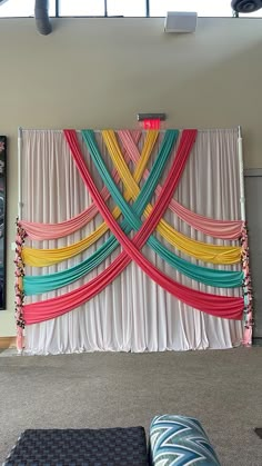 the backdrop is decorated with colorful ribbons on it's sides and hanging from the ceiling