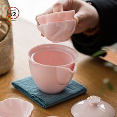 a person is pouring tea into pink cups