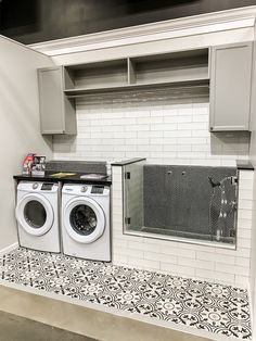 a washer and dryer in a room with white tiles on the floor,