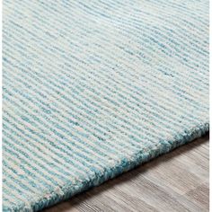 a blue and white rug on top of a wooden floor next to a wood floor