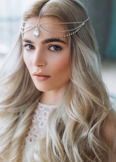 a woman with long blonde hair wearing a head chain and a tiara on her head