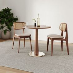 a table with two chairs and a wine bottle on top of it next to a rug