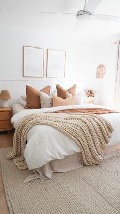 a bedroom with white walls and neutral bedding