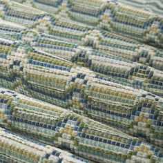 an up close view of a quilted material with blue, green and white squares