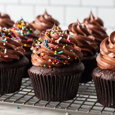 cupcakes with chocolate frosting and sprinkles on a cooling rack