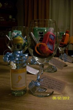 two wine glasses sitting on top of a table next to a bottle of wine and candy