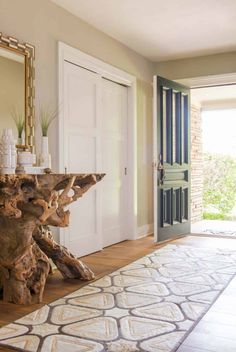 a wooden table sitting on top of a hard wood floor next to a door and window