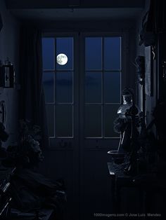 a full moon is seen through the window of a dark room