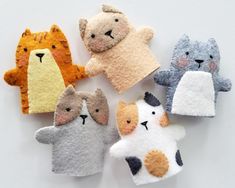 five felt animal finger puppets on a white surface