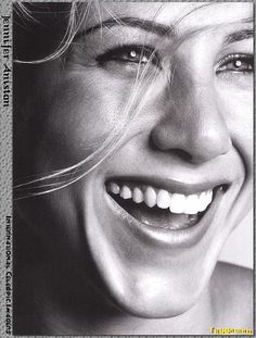 a black and white photo of a smiling woman with her hair blowing in the wind