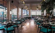 an empty restaurant with lots of tables and chairs in front of large windows overlooking the city