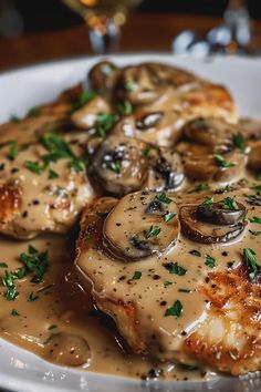 a white plate topped with meat covered in mushroom gravy