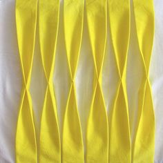 several pieces of yellow fabric with wavy lines on them