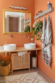 a bathroom with orange walls and two sinks